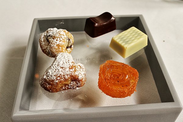 small bites of cookies and chocolates on a square glass plate