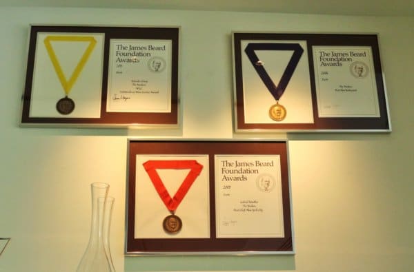 three awards and medals framed on a wall