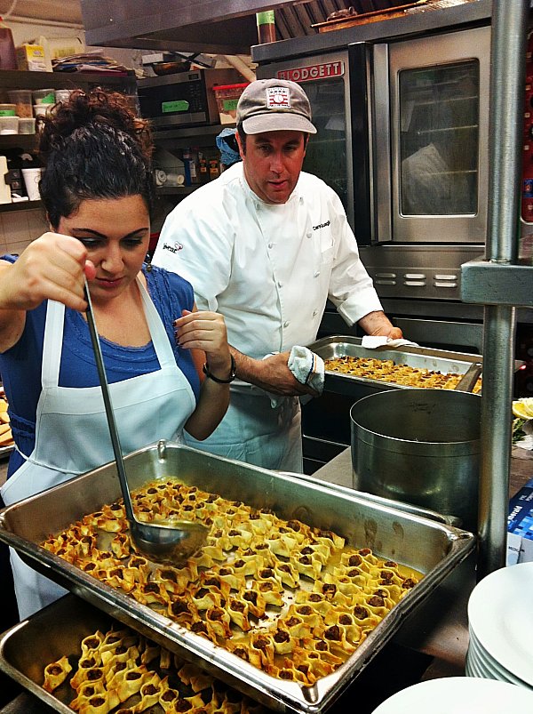 A man and woman cooking food in a professional kitchen