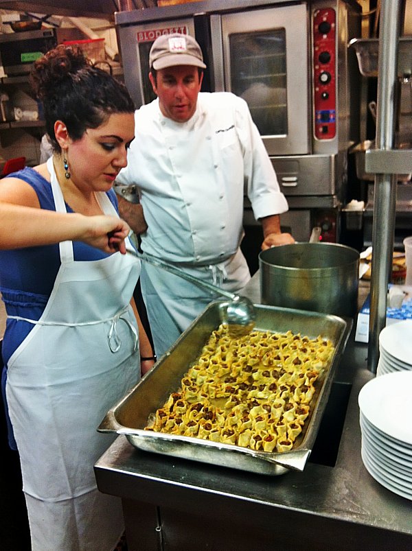 A man and woman preparing food in a kitchen