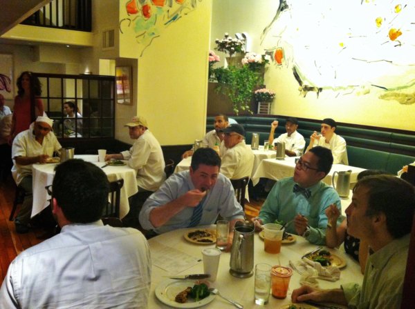 A group of people sitting at a table in a restaurant