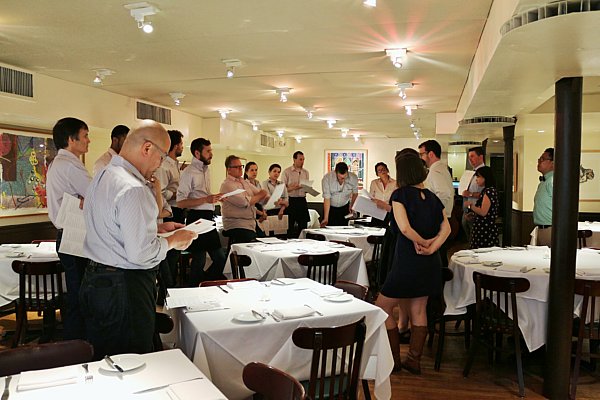 A group of people standing in a restaurant dining room