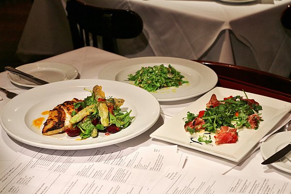 plates of food next to sheets of paper on a dining table