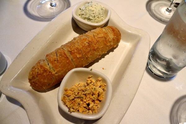 overhead view of a small loaf of bread with two containers of spread on either side