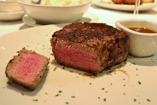cross section of a medium rare filet mignon steak on a white plate