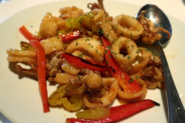 closeup of a plate of fried calamari with banana peppers and red peppers