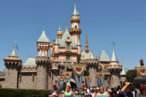 A group of people standing in front of Sleepy Beauty Castle at Disneyland Park