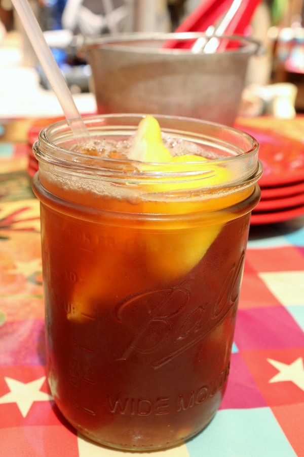 A closeup of ice tea with lemon in a mason jar on a table