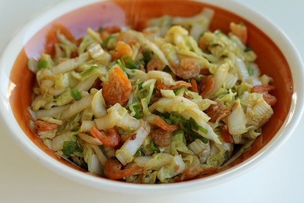 a brown and white bowl filled with stir-fried cabbage with dried shrimp