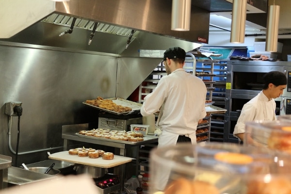 A group of people preparing food in a commercial kitchen