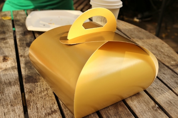 a gold colored square box on a wooden table