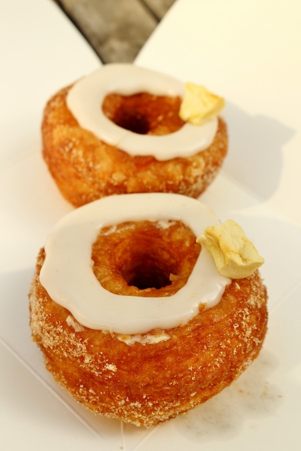A close up of two Cronuts on a white surface