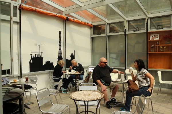 A group of people sitting at tables outside a restaurant