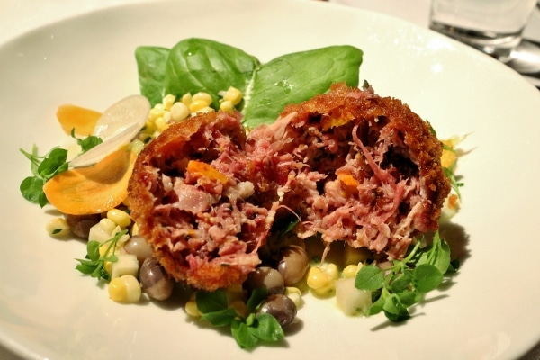 a cross section of a round fried croquette showing the meat filled center