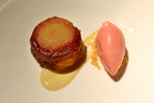 a plate of dessert with a small round pastry and scoop of pink ice cream