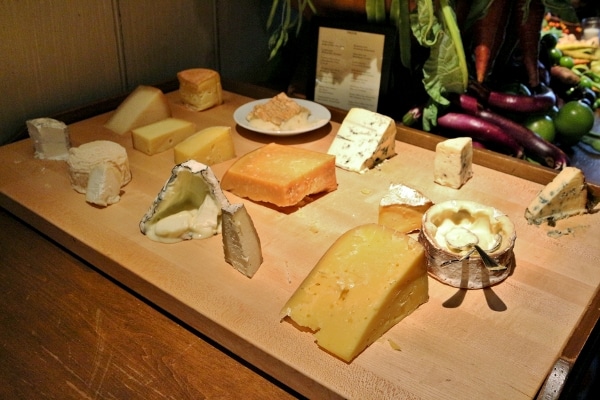 a large wooden board topped with a variety of cheeses