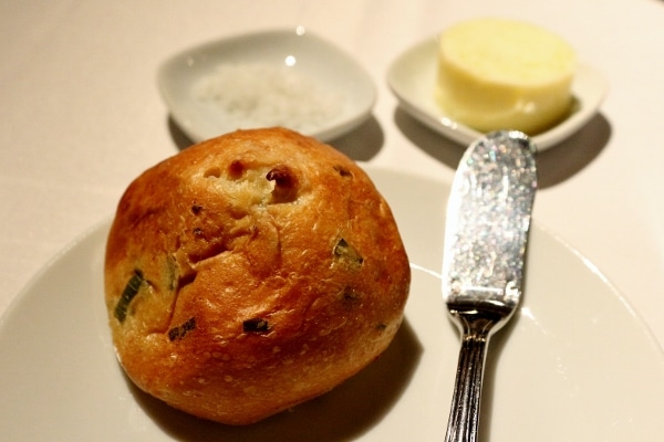 A closeup of a bread roll on a small white plate