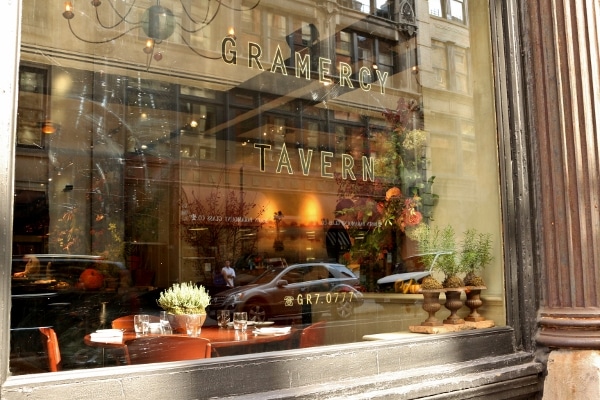 a glass window that says Gramercy Tavern with a view into the restaurant