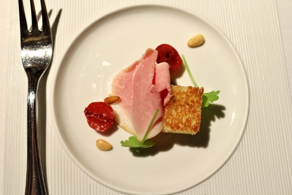 overhead view of a white plate with a cube of toasted bread and slice of ham