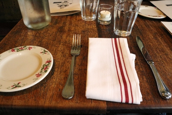 a white and red striped cloth napkin and utensils on a wooden table