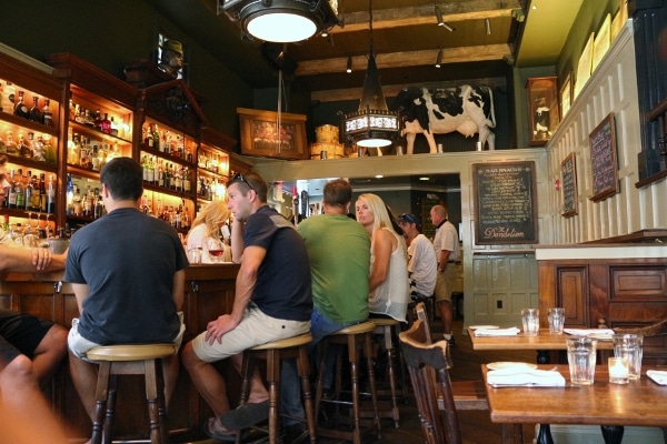 A group of people sitting around a bar in a restaurant