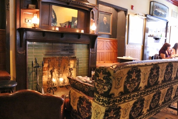 a sofa in front of a fireplace surrounded with green tile