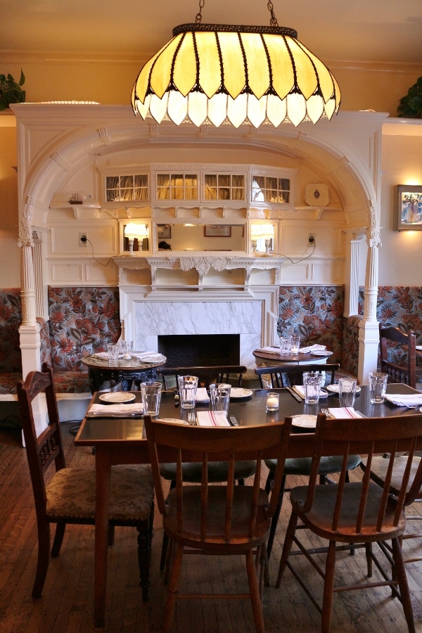 a wooden dining table and chairs under a large lighting fixture