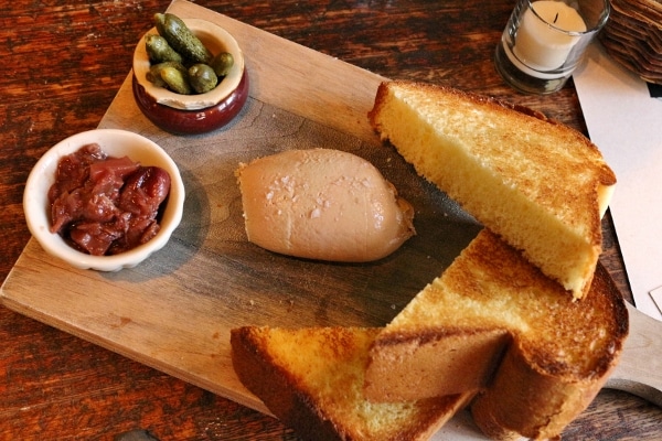 overhead view of a wooden board with toasted bread and pate