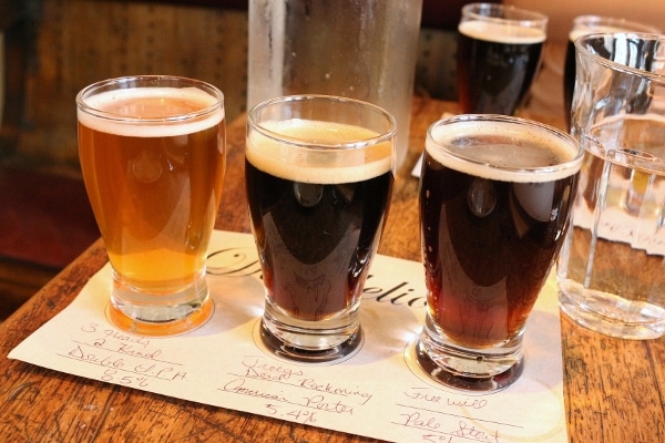 a flight of three beers in small glasses placed on a white paper