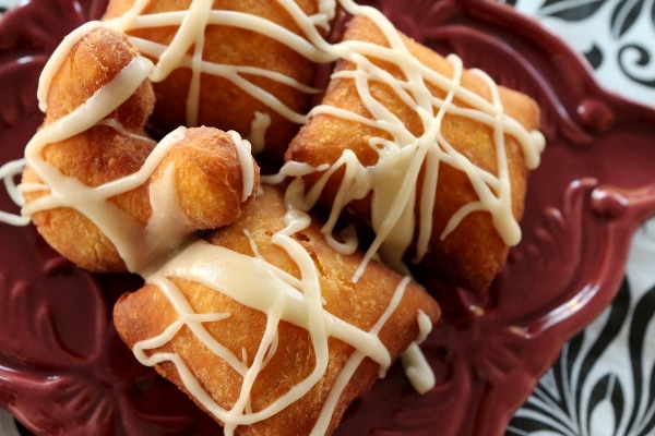 overhead view of a plate of glazed fried beignets in Mickey shapes and squares