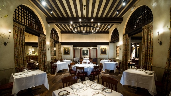 a large empty restaurant dining room with dark wooden beams overhead