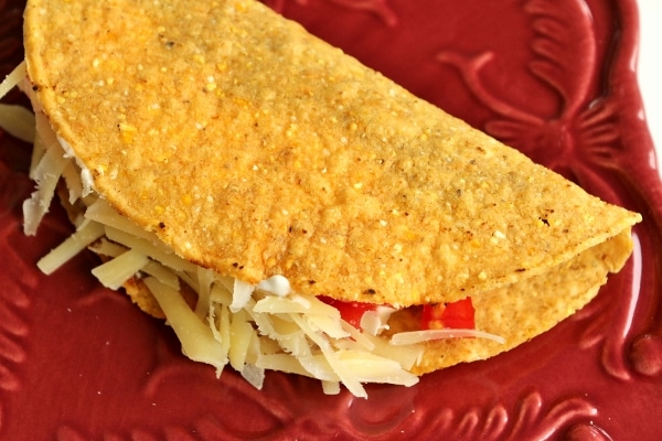 overhead view of a hard taco on a dark red plate