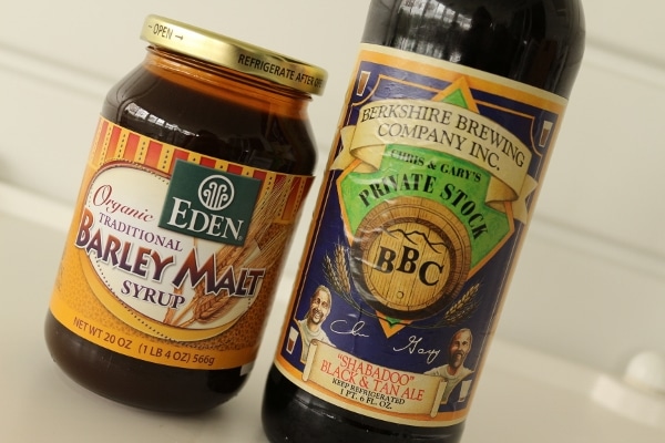 a jar of barley malt syrup next to a bottle of beer