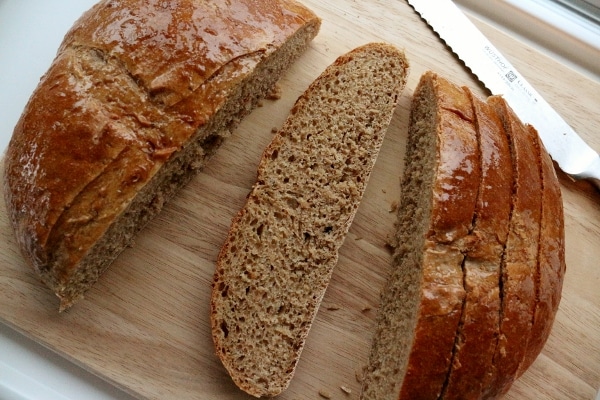 overhead view of sliced brown bread on a wooden board