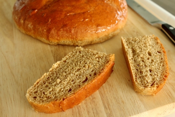 a closeup of sliced pieces of glazed brown bread on a wooden board