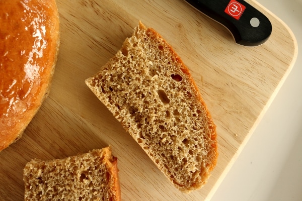 overhead closeup of pieces of sliced brown bread on a wooden board