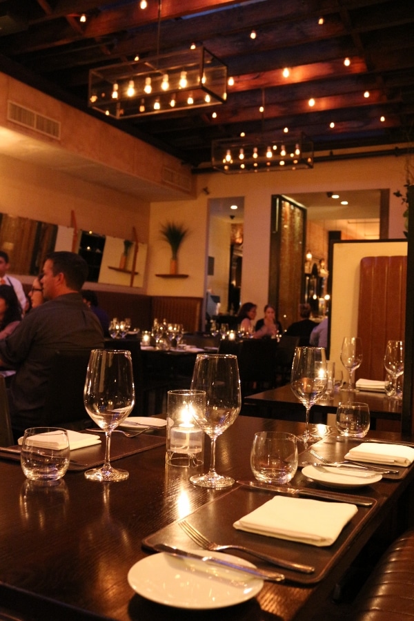 interior of a restaurant with tables set with white linen napkins and wine glasses