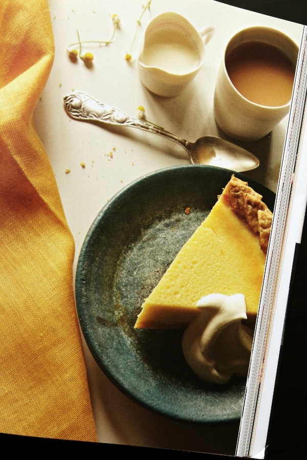 a slice of yellow custard pie on a dark colored plate