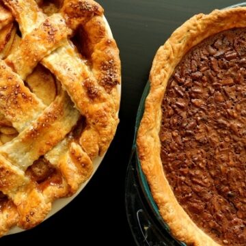 overhead view of an apple pie and a pecan pie side by side on a table