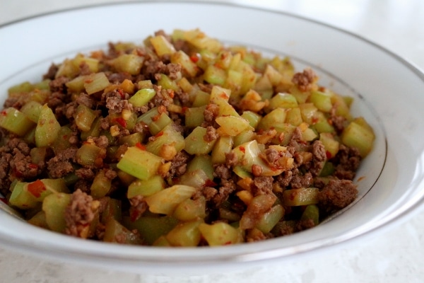 side view of stir-fried ground beef with celery in a white bowl