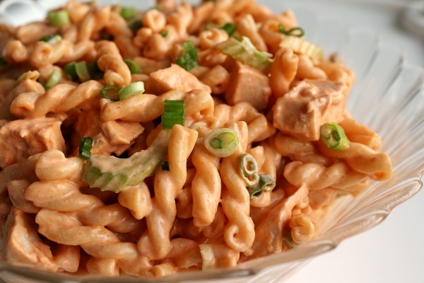 pasta salad made with gemelli pasta, chicken, and celery with an orange colored dressing