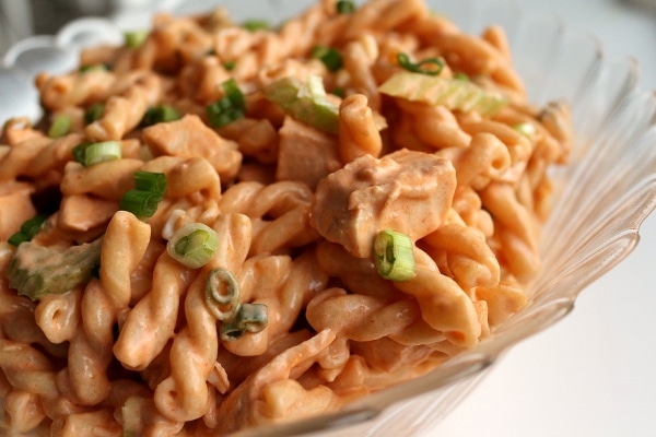 A closeup of buffalo chicken pasta salad in a large glass bowl