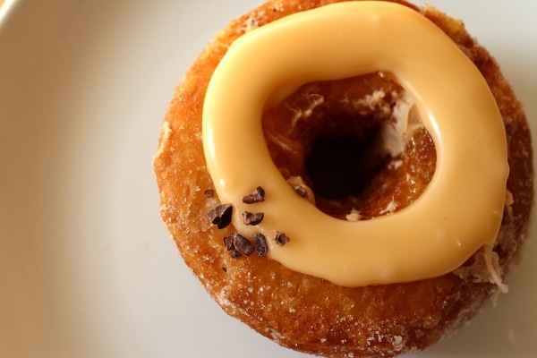 overhead closeup of a fried doughnut topped with a ring of orange sauce