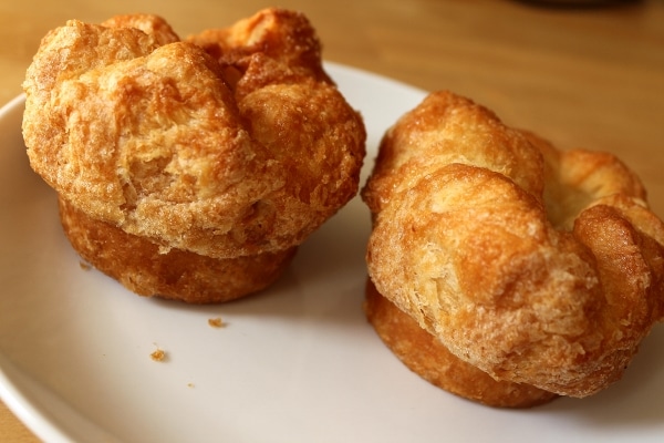 two round pastries with puffed up tops on a white plate