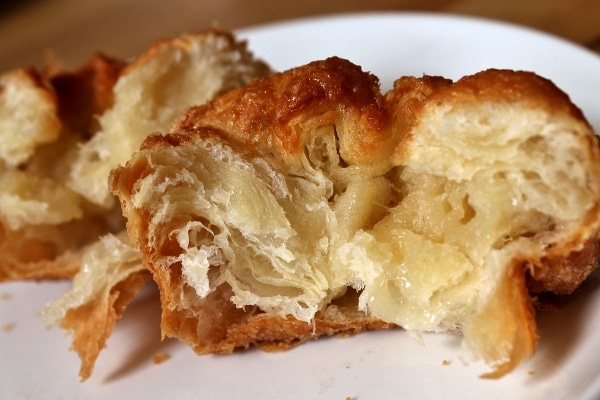 a cross section of a crusty flaky pastry with layers of dough inside