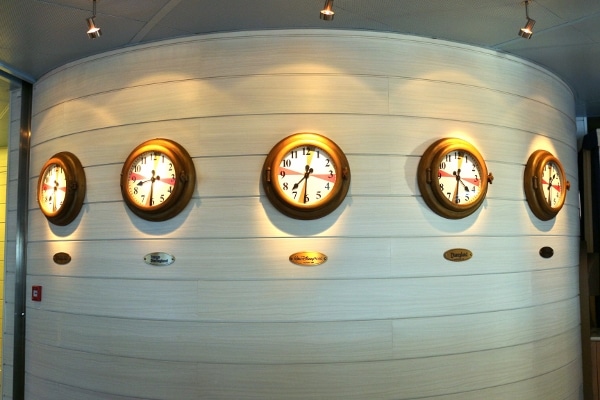 a row of clocks on a curved white wall