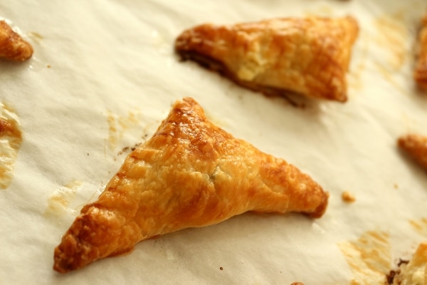 Closeup of a golden brown puff pastry triangle on a baking sheet