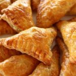 A platter of crispy, golden puff pastry triangles.