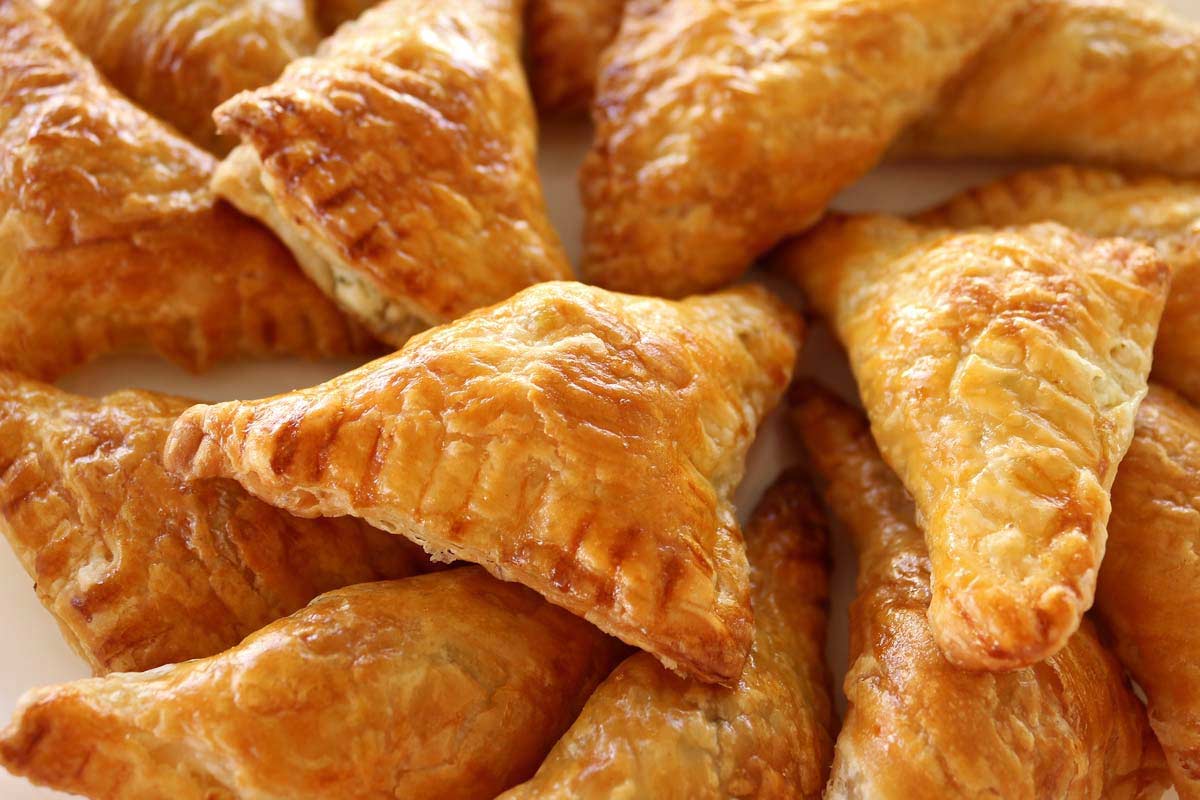 A platter of crispy, golden puff pastry triangles.