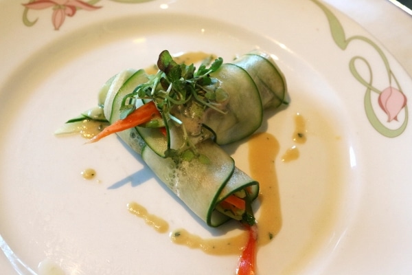 two rolls wrapped with cucumber slices on a white plate